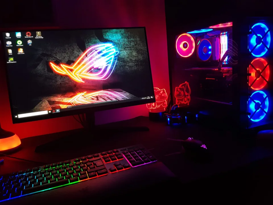 Gaming-Arbeitsplatz mit RGB-beleuchtetem PC, Monitor, Tastatur und Maus.
